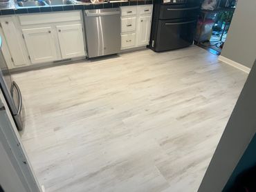 Bright kitchen with light wood flooring and modern appliances.