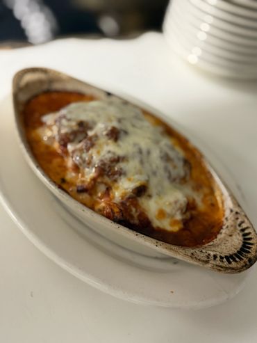 Baked lasagna in a white dish.