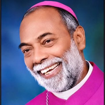 Smiling clergyman with gray beard and purple vestments.