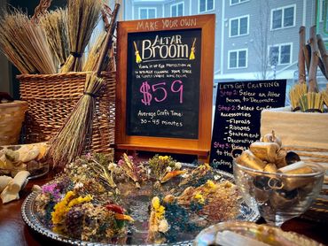 small brooms made of broomcorn and dried flowers