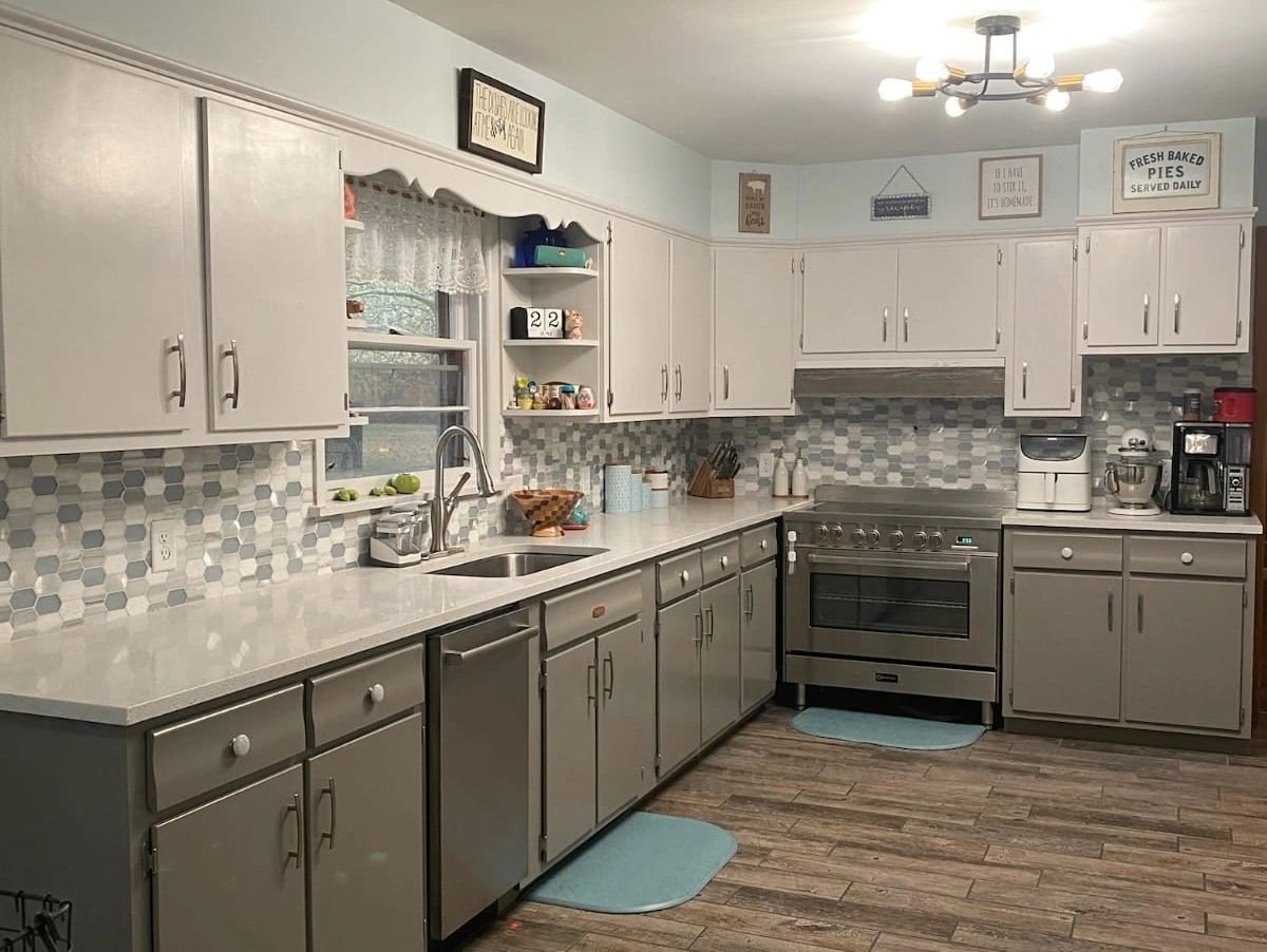 Remodelled kitchen with new mosaic tile backsplash, laminate flooring, shining cabinets & sink