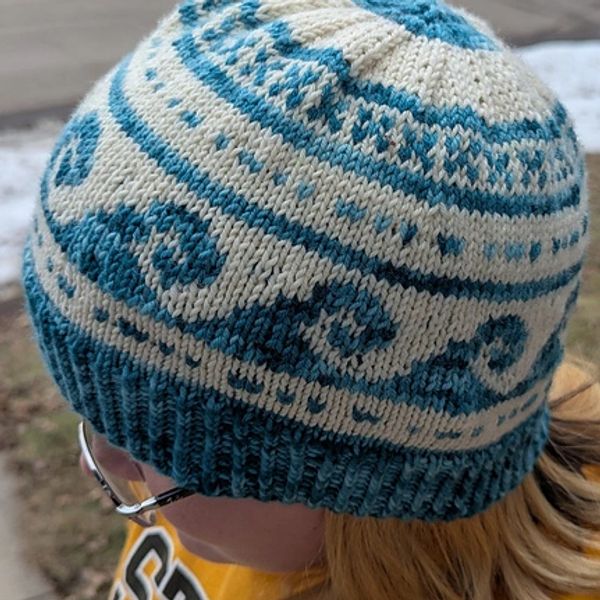 Beige and blue knitted hat with wave pattern.
