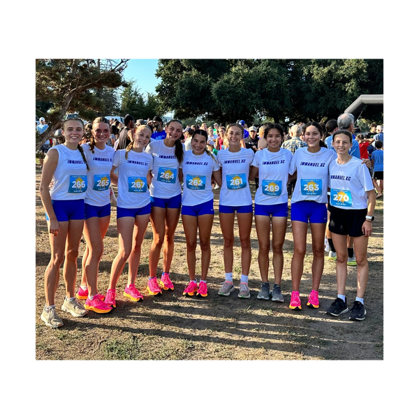 A group of young female runners in matching Immanuel XC uniforms posing outdoors.