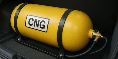 Yellow compressed natural gas (CNG) cylinder installed in a vehicle.