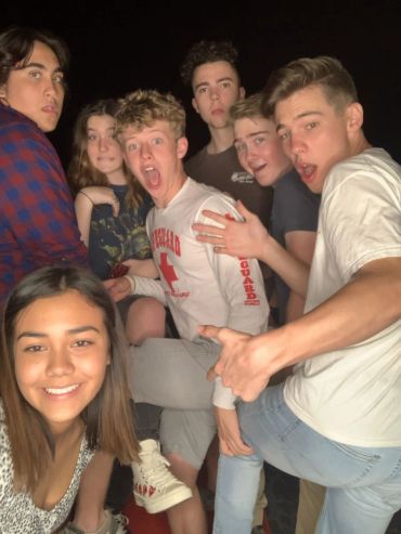 Group of teens posing with playful expressions.