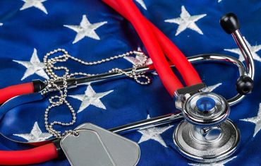 Stethoscope and dog tags on American flag symbolizing healthcare and military service.