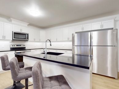 Modern kitchen with white cabinets and black countertop island.