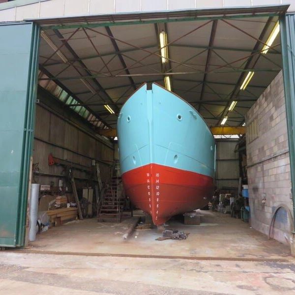 Boat under construction in a shipyard.