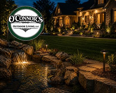 Elegant nighttime garden with illuminated waterfall and pathway lighting.