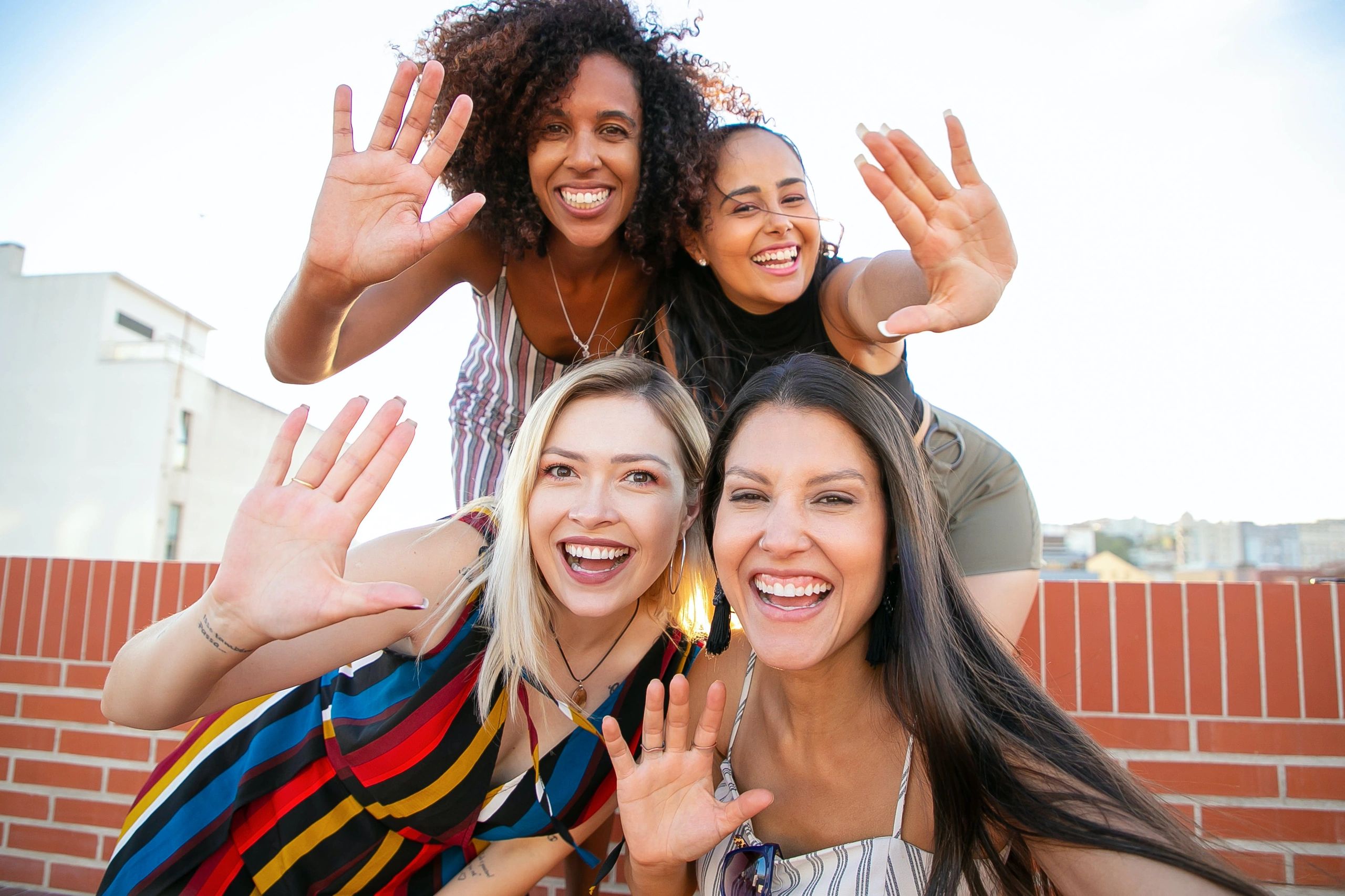 Photo by Kampus Production: smiling-diverse-women-showing-hi-sign-while-taking-selfie-on-terrace