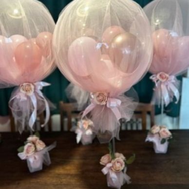 Bubble balloon on a stick with flower arrangement in pink