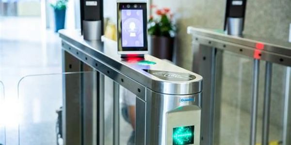 Modern security turnstile with facial recognition and card scanning technology.