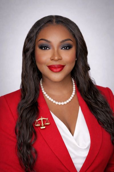 Confident woman in red blazer with pearl necklace.