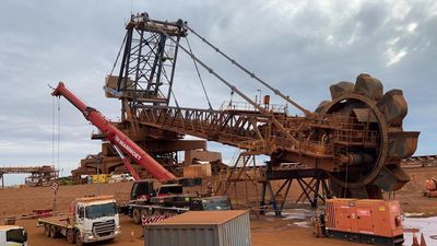 Large industrial mining machinery operating under a cloudy sky.