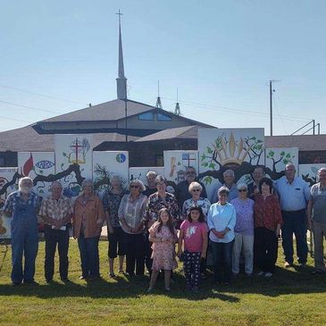 Members of Grandview UMC stand in front of the mural created by various churches in the area for the