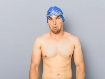 Confused male swimmer, in blue swimming cap