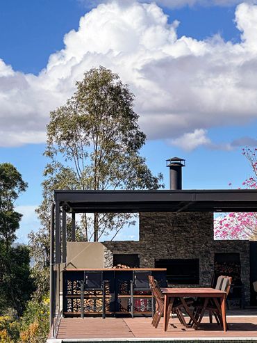 Garage rooftop entertainment area with built in fire pit, and tiling to match existing pool area