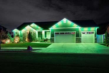 A house illuminated with green and white lights at night.