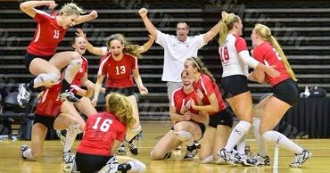 Volleyball team celebrating a victory on the court.