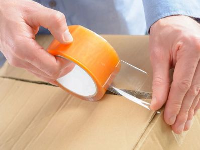 packing
moving
tape 
taping box closed
movers
pack
unpacking
unpack
roll of tape
person packing