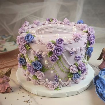 Lavender-themed birthday cake with intricate purple and blue floral decorations.