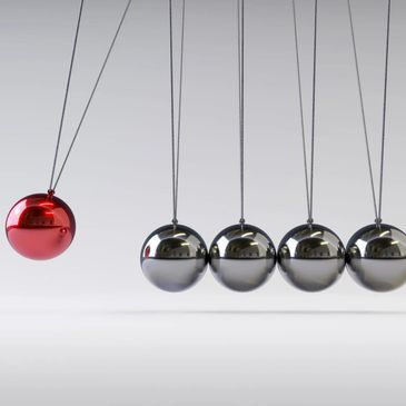 Newton's cradle with one red ball and four silver balls suspended.