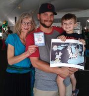 A dad hold his boy; the boy holds the print.