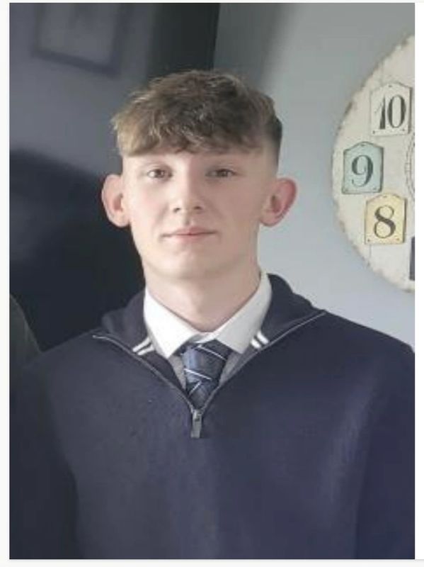 Young man in a formal outfit with a clock in the background.