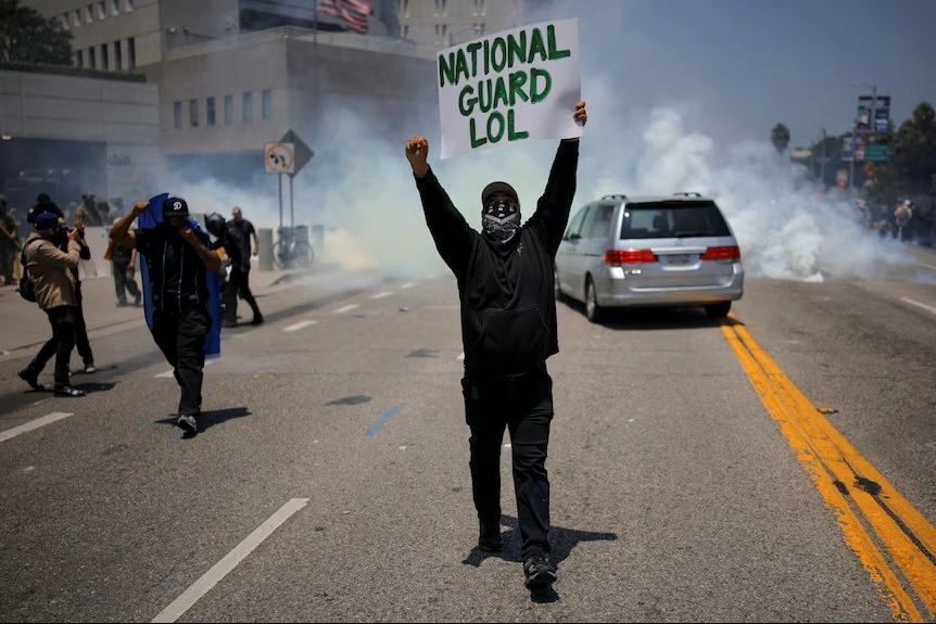 Rioter holding up a sign that says "National Guard LOL"