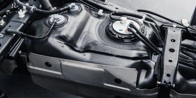 Close-up of a car's fuel tank and surrounding chassis components.
