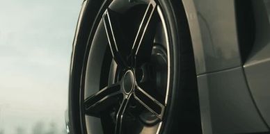 Close-up of a sleek black car wheel with a modern five-spoke design.