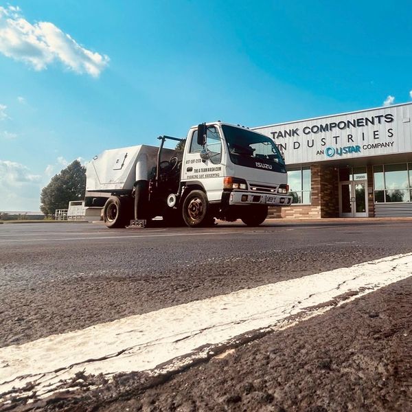 Loose gravel collects along curbs where routine sweeping removes it before rainfall can carry it tow