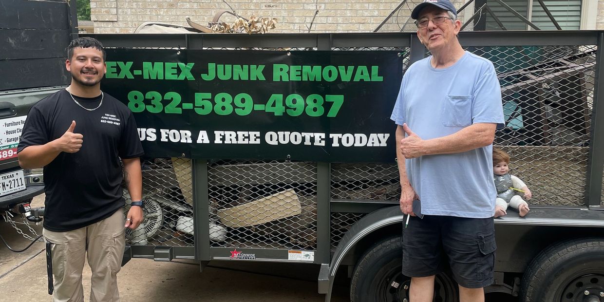 Two men standing by a junk removal trailer with a baby sitting inside it. Katy junk removal, full service junk removal, eco-friendly junk removal