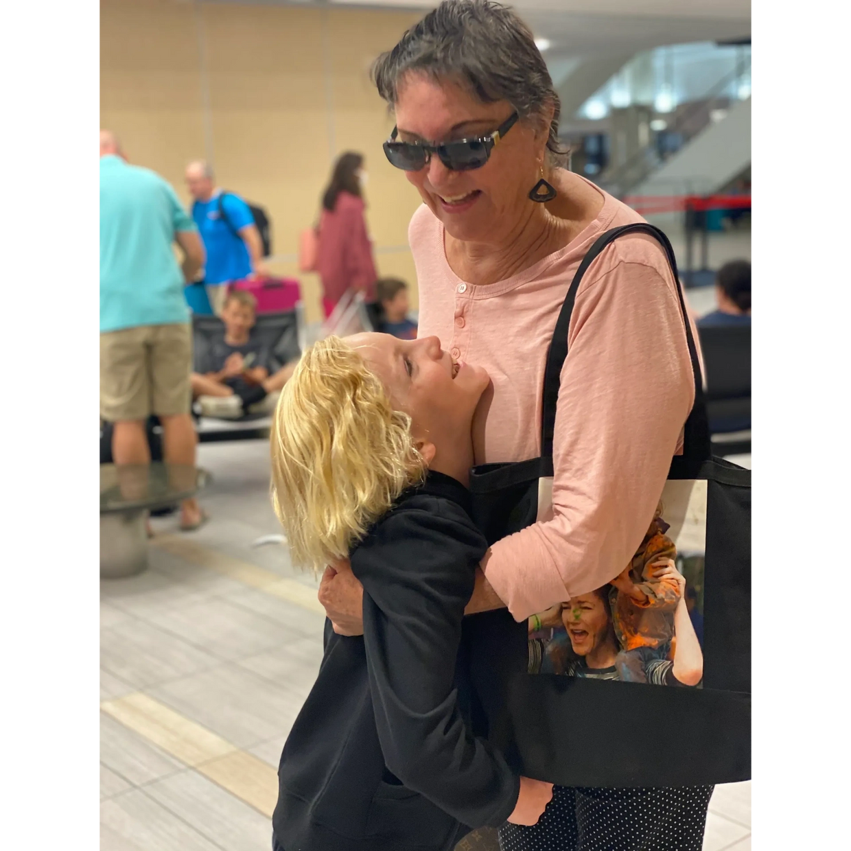 Spiritual Medium, Rosemary Altea embraces her grandson the airport.