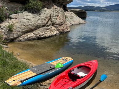 Kayak and paddleboard resting by the lakeside.