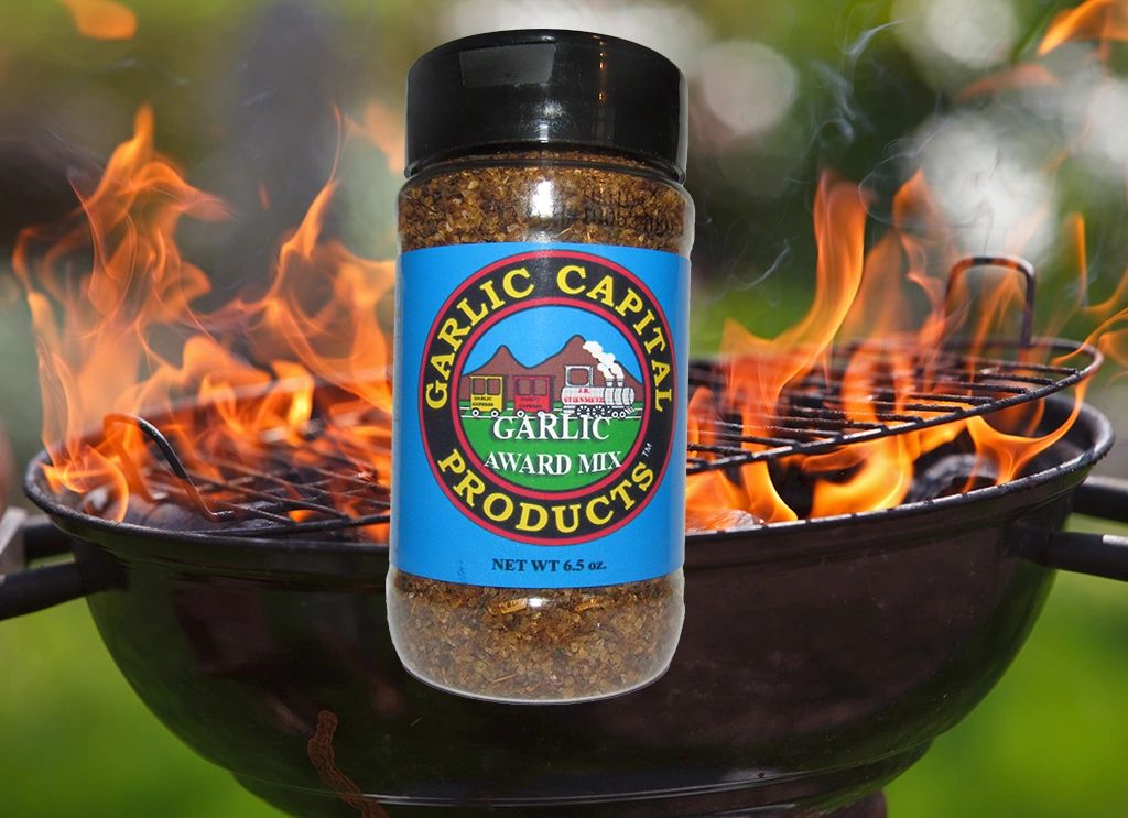 Jar of Garlic Award Mix Seasoning in front of a burning barbecue pit