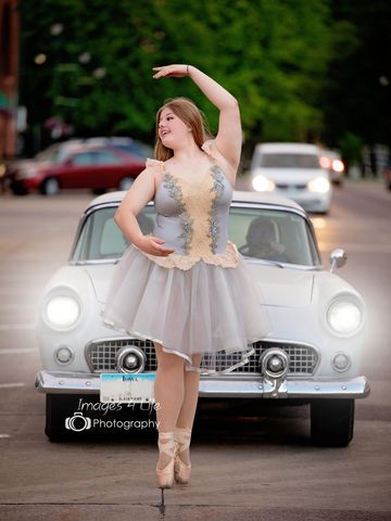 senior girl dancing in front of vintage car 