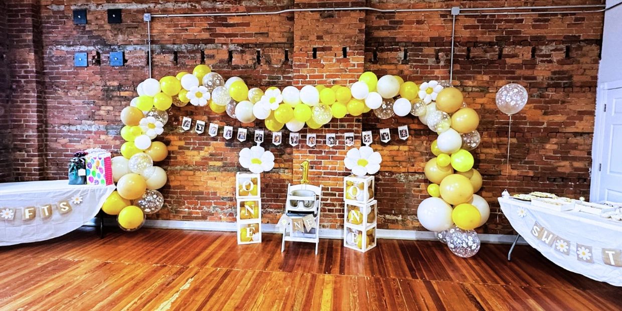 Yellow balloon arch for a birthday party in the great room