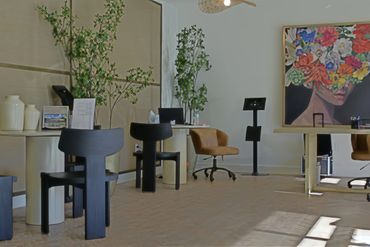 Modern office with artistic floral painting and stylish chairs.