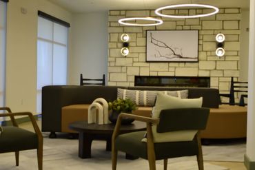 Modern living room with circular ceiling lights and stone wall fireplace.