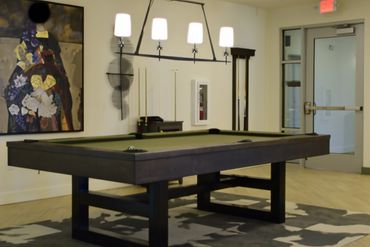 Modern pool table in a stylish room with artwork and lighting.