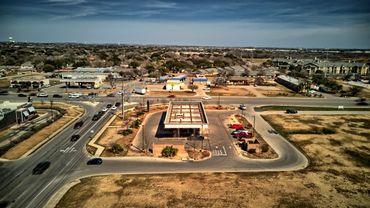 Aerial view of a gas station surrounded by roads and residential buildings.