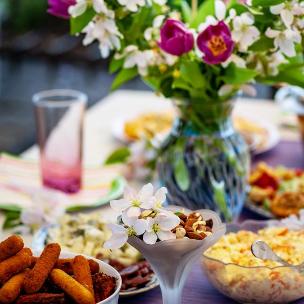 A table set with various snacks and a vase of flowers.