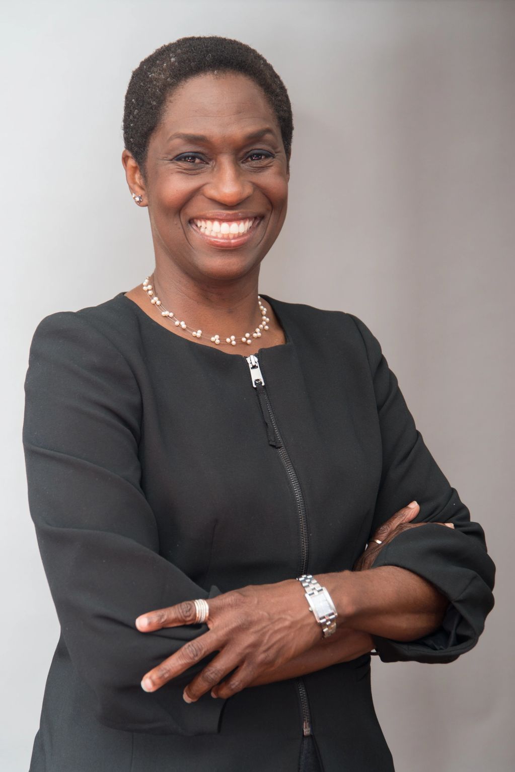 Woman wearing a black suit, facing camera and smiling