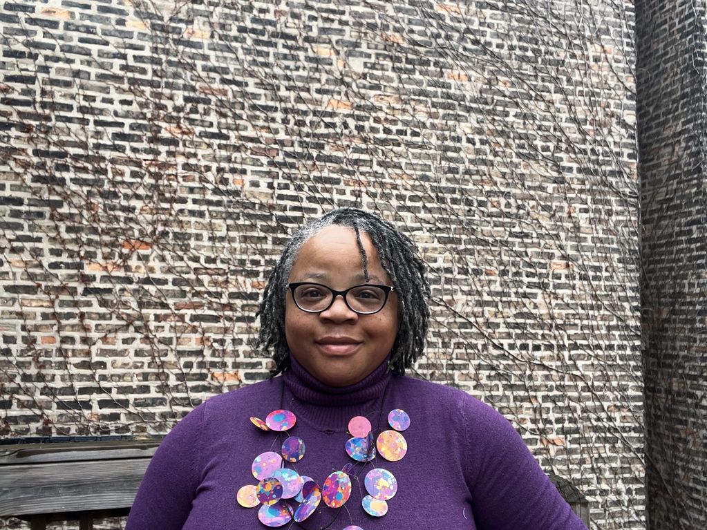 Woman wearing purple, facing camera and smiling