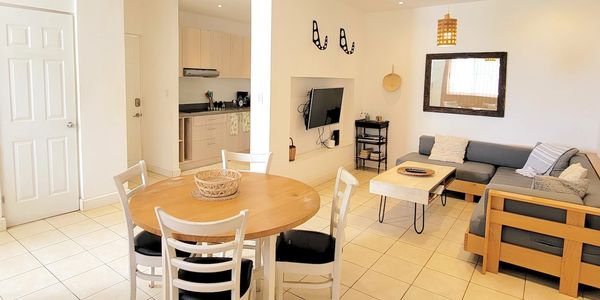 Bright modern living and dining area with wooden furniture and minimal decor.