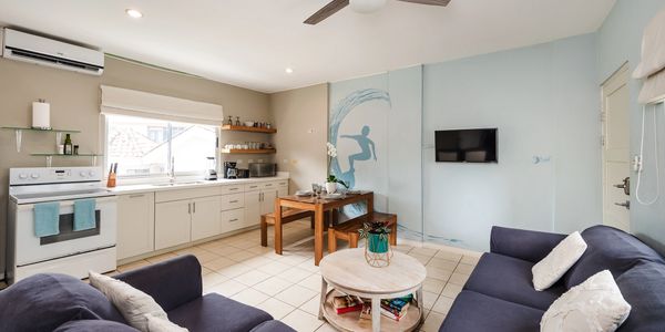 Cozy open kitchen and living room with modern decor and natural light.