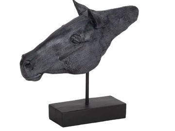 Black horse head sculpture on stand.