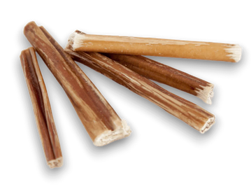 Four brown natural dog chew sticks on a black background.