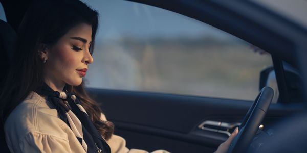Woman concentrating while driving a car at dusk.